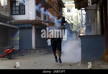 Un dévot népalais a renvoyé une cartouche de gaz lacrymogène vers les forces de police pendant un affrontement s'est ensuivi entre la police et les locaux à Pulchok, ce dernier ayant lancé Machhinranath Jatra en tirant le char qui défiait les ordres d'interdiction à Lalitpur, au Népal 3 septembre 2020. Selon le surintendant principal Tek Prasad Rai, chef de la police métropolitaine de Lalitpur, environ 800 personnes se sont rassemblées à Pulchowk pour tirer le char. Un clash s'ensuivit lorsque la police essaya des empêcher de tirer le char en raison des restrictions du coronavirus. (Photo par Saroj Baizu/NurPhoto) Banque D'Images