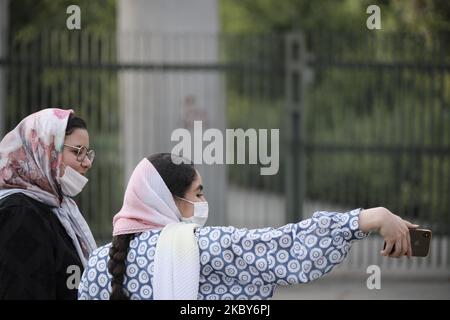 Deux femmes iraniennes portant un masque facial protecteur prennent un selfie alors qu'elles se trouvent dans la rue du quartier des affaires de Téhéran, dans le cadre de la nouvelle épidémie de coronavirus (COVID-19) en Iran, sur le 5 juillet 2020. (Photo de Morteza Nikoubazl/NurPhoto) Banque D'Images