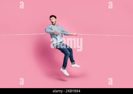 Profil côté pleine longueur photo de type saut tirer corde regarder arrière vide espace discount isolé couleur pastel arrière-plan Banque D'Images