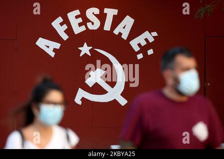 Les personnes portant des masques faciaux marchent devant le symbole communiste du marteau et de la faucille pendant la Festa do Avante du Parti communiste portugais! (Festival Avante) à Seixal, en périphérie de Lisbonne, sur 6 septembre 2020. Le rassemblement annuel de trois jours, qui attire normalement des milliers de visiteurs et de suiveurs de partis, a été touché cette année en raison des restrictions du coronavirus COVID-19 concernant la vente de billets et la fréquentation, après que des préoccupations aient été soulevées au sujet de la propagation du virus. (Photo par Pedro Fiúza/NurPhoto) Banque D'Images