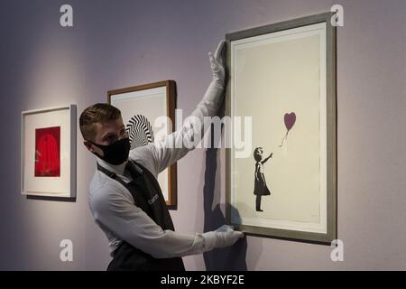 (NOTE DE L'ÉDITEUR: Usage éditorial seulement) Un membre du personnel pose avec 'fille avec ballon - couleur AP (violet)' sérigraphie en couleurs, 2004, par Banksy (prix de vente estimé ?250 000-350 000) pendant un aperçu de la presse de 'Banksy: Je ne peux pas croire que vous morons en fait acheter cette vente en ligne de SH*t chez Christie's on 09 septembre 2020 à Londres, en Angleterre. La vente, qui a lieu du 10 au 23 septembre, porte le nom de 2007 morons de sérigraphie de Banksy (Sepia), qui fait référence à la vente record des tournesols de Vincent van Gogh à Christie's en 1987. (Photo de Wiktor Szymanowicz/NurPhoto) Banque D'Images