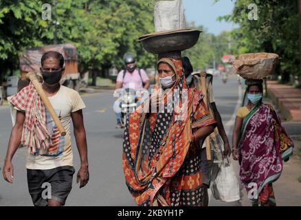 Les travailleurs salariés quotidiens portent un masque de protection lorsqu'ils se dirigent vers leur lieu de travail après un verrouillage de détente dans la capitale de l'État indien de l'est, Bhubaneswar, sur 10 septembre 2020. (Photo par STR/NurPhoto) Banque D'Images