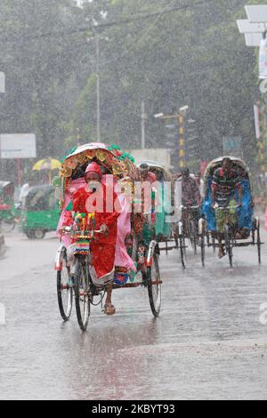 Les hommes tirent des pousse-pousse pendant les pluies à Dhaka, au Bangladesh, sur 13 septembre 2020. (Photo de Rehman Asad/NurPhoto) Banque D'Images