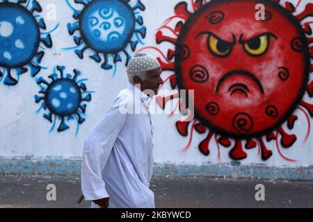 Un homme palestinien passe devant une fresque représentant le coronavirus, à Deir Al-Balah, dans le centre de la bande de Gaza, le 14 septembre 2020.- des artistes palestiniens ont peint des peintures murales à différents endroits de la bande de Gaza dans le cadre d'une campagne de sensibilisation à la prévention de la COVID-19 lors de la pandémie du coronavirus COVID-19. (Photo de Majdi Fathi/NurPhoto) Banque D'Images