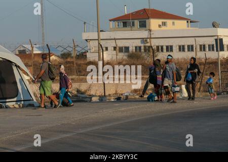 Les familles de migrants d'Afghanistan sont vues en attente, s'enregistrer, avoir un test rapide de coronavirus Covid-19 et entrer dans le nouveau camp de réfugiés de l'île de Lesbos, Grèce après le grand incendie qui a complètement détruit le camp de Moria, le premier accueil et l'enregistrement camp de réfugiés sur l'île. Le nouveau camp près de la capitale de l'île, Mytilene, à Mavrovouni ou Kara Tepe, est un ancien terrain de tir militaire, mais les migrants sont sceptiques à entrer car il s'agit d'une installation fermée pour le moment qui ne leur permettra pas de se promener librement, malgré le fait que la nourriture, les tentes, toilettes et m Banque D'Images