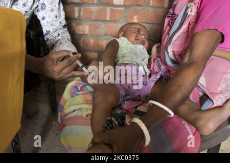 Un assistant sanitaire applique un vaccin à un enfant dans une zone rurale du Bangladesh le 17 septembre 2020. Le Programme élargi de vaccination (PEV) a été établi en 1976 pour garantir que les nourrissons/enfants et les mères ont accès aux vaccins couramment recommandés pour les nourrissons/enfants. Six maladies évitables par la vaccination sont la tuberculose, la poliomyélite, la diphtérie, le tétanos, la coqueluche et la rougeole. (Photo de Zakir Hossain Chowdhury/NurPhoto) Banque D'Images