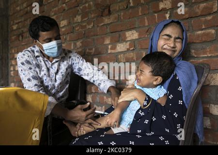 Un assistant sanitaire applique un vaccin à un enfant dans une zone rurale du Bangladesh le 17 septembre 2020. Le Programme élargi de vaccination (PEV) a été établi en 1976 pour garantir que les nourrissons/enfants et les mères ont accès aux vaccins couramment recommandés pour les nourrissons/enfants. Six maladies évitables par la vaccination sont la tuberculose, la poliomyélite, la diphtérie, le tétanos, la coqueluche et la rougeole. (Photo de Zakir Hossain Chowdhury/NurPhoto) Banque D'Images