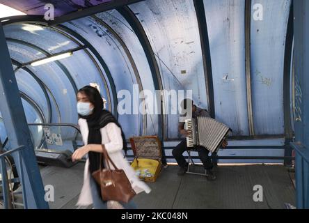 Une iranienne portant un masque protecteur alors qu’une musicienne de rue joue de l’accordéon sur un pont dans le quartier des affaires de Téhéran, dans le contexte de la nouvelle épidémie de coronavirus (COVID-19) en Iran, au 17 septembre 2020. Le secrétaire d'État américain Mike Pompeo a annoncé que les États-Unis se sont mis à réémettre samedi, 19 septembre, toutes les sanctions des Nations Unies contre l'Iran. MORTEZA NIKOUBAZL/NurPhoto (photo de Morteza Nikoubazl/NurPhoto) Banque D'Images