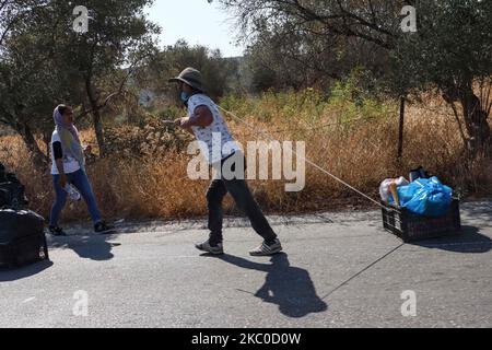 Les séquelles de l'incendie dans le camp de réfugiés de Moria et les oliveraies voisines. Les migrants et les réfugiés sont à la recherche de leurs effets personnels ou d'articles utiles pour leur nouvelle résidence à Kara Tepe, à l'intérieur de la zone brûlée des tentes, des installations officielles et des cendres, pour les y déplacer. Les demandeurs d'asile ont été transférés dans le nouveau camp de réfugiés de Kara Tepe - Mavrovouni ancienne zone militaire, champ de tir de l'armée hellénique, près de la ville de Mytilène, sur l'île de Lesbos, en Grèce. Le nouveau camp temporaire a été créé après le feu de 9 septembre 2020, l'un des plus grands réfugiés d'Europe Banque D'Images