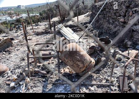 Les séquelles de l'incendie dans le camp de réfugiés de Moria et les oliveraies voisines. Les migrants et les réfugiés sont à la recherche de leurs effets personnels ou d'articles utiles pour leur nouvelle résidence à Kara Tepe, à l'intérieur de la zone brûlée des tentes, des installations officielles et des cendres, pour les y déplacer. Les demandeurs d'asile ont été transférés dans le nouveau camp de réfugiés de Kara Tepe - Mavrovouni ancienne zone militaire, champ de tir de l'armée hellénique, près de la ville de Mytilène, sur l'île de Lesbos, en Grèce. Le nouveau camp temporaire a été créé après le feu de 9 septembre 2020, l'un des plus grands réfugiés d'Europe Banque D'Images