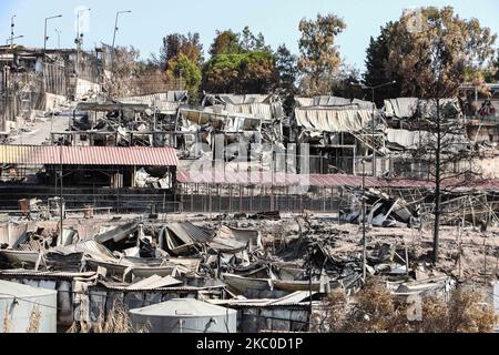 Les séquelles de l'incendie dans le camp de réfugiés de Moria et les oliveraies voisines. Les migrants et les réfugiés sont à la recherche de leurs effets personnels ou d'articles utiles pour leur nouvelle résidence à Kara Tepe, à l'intérieur de la zone brûlée des tentes, des installations officielles et des cendres, pour les y déplacer. Les demandeurs d'asile ont été transférés dans le nouveau camp de réfugiés de Kara Tepe - Mavrovouni ancienne zone militaire, champ de tir de l'armée hellénique, près de la ville de Mytilène, sur l'île de Lesbos, en Grèce. Le nouveau camp temporaire a été créé après le feu de 9 septembre 2020, l'un des plus grands réfugiés d'Europe Banque D'Images