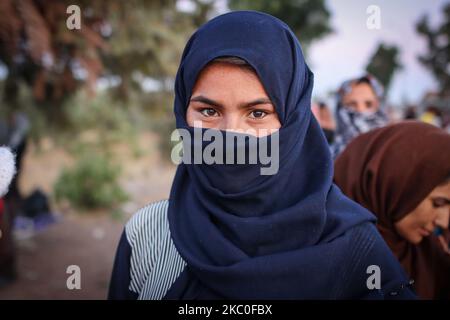 Portrait d'une jeune femme en attendant la nourriture. Des femmes de tous âges, de petits enfants, des filles, des adultes et des personnes âgées, sont vues dans la file d'attente demandant et exigeant de la nourriture des policiers. Ces demandeurs d'asile refusent d'entrer et de vivre dans le nouveau camp en espérant qu'ils seront transférés dans un autre pays européen, la plupart d'entre eux étant d'Afghanistan, Ils restent en bord de route dans des camps de fortune entre le nouveau camp de réfugiés de Kara Tepe ou Mavrovouni construit par l'armée grecque avec des tentes du HCR et la ville de Mytilène ( Mitilini ) avec des milliers de réfugiés et de migrants après l'incendie du point d'accès de Moria, à Septe Banque D'Images