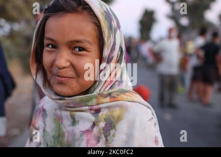 Portrait d'une fille en attendant la nourriture. Des femmes de tous âges, de petits enfants, des filles, des adultes et des personnes âgées, sont vues dans la file d'attente demandant et exigeant de la nourriture des policiers. Ces demandeurs d'asile refusent d'entrer et de vivre dans le nouveau camp en espérant qu'ils seront transférés dans un autre pays européen, la plupart d'entre eux étant d'Afghanistan, Ils restent en bord de route dans des camps de fortune entre le nouveau camp de réfugiés de Kara Tepe ou Mavrovouni construit par l'armée grecque avec des tentes du HCR et la ville de Mytilène ( Mitilini ) avec des milliers de réfugiés et de migrants après l'incendie du hotspot de Moria, le septembre Banque D'Images