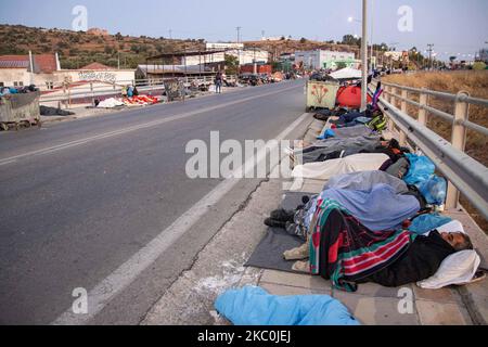 Réfugiés et migrants dormant dans la rue. Tôt le matin avec plus de 10,000 demandeurs d'asile dorment au bord de la route après l'incendie dans le camp de réfugiés de Moria, le centre hotspot pour l'identification et l'enregistrement. Les réfugiés sans abri et les migrants sans abri ni installations telles que les toilettes ou l'eau courante vivent sur la route entre la ville de Mytilène ou Mitlini, la capitale de l'île et Moria, près de Caratepe résultant la route principale de l'île à fermer, Dans des tentes improvisées, puisqu'il n'y avait pas de place pour les accueillir à cette époque, le nouveau camp temporaire de réfugiés de Kara Tepe ou Mavrovouni a été créé. Banque D'Images