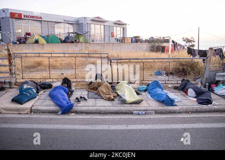 Réfugiés et migrants dormant dans la rue. Tôt le matin avec plus de 10,000 demandeurs d'asile dorment au bord de la route après l'incendie dans le camp de réfugiés de Moria, le centre hotspot pour l'identification et l'enregistrement. Les réfugiés sans abri et les migrants sans abri ni installations telles que les toilettes ou l'eau courante vivent sur la route entre la ville de Mytilène ou Mitlini, la capitale de l'île et Moria, près de Caratepe résultant la route principale de l'île à fermer, Dans des tentes improvisées, puisqu'il n'y avait pas de place pour les accueillir à cette époque, le nouveau camp temporaire de réfugiés de Kara Tepe ou Mavrovouni a été créé. Banque D'Images