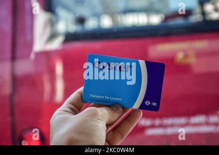 Londres, Angleterre - 07 juillet 2017: Main tenant la carte bleue Oyster derrière le double-drapeau rouge de bus Banque D'Images