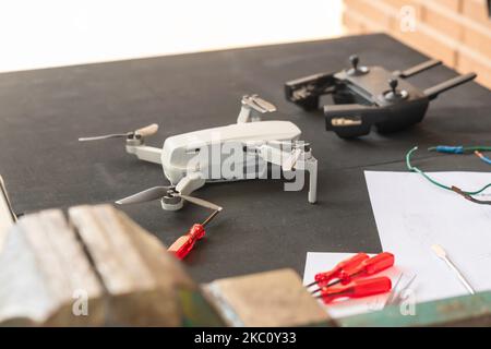 Mise au point sélective d'un petit drone sur la banque d'outils avec télécommande et différents outils autour de la table Banque D'Images