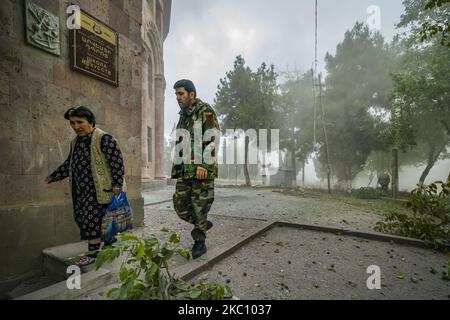 Une femme et un soldat entrent dans un refuge pendant qu'un bombardement de l'armée azerbaïdjanaise surpasse le village de Martuni pendant les combats dans le Haut-Karabakh sur 1 octobre 2020. (Photo de Celestino Arce/NurPhoto) Banque D'Images