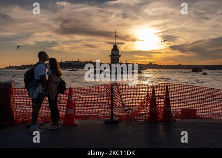 Un couple vu au coucher du soleil au bord de la mer dans le quartier d'Uskudar à Istanbul, en Turquie, avec la tour historique de la jeune fille à l'arrière-plan, sur 2 octobre 2020. À ce jour, le nombre de décès liés au coronavirus est de 8 325 en Turquie. (Photo par Erhan Demirtas/NurPhoto) Banque D'Images