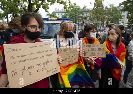 Des manifestants portant un masque facial protecteur sont vus enveloppés de drapeaux LGBT portant des panneaux sur 4 septembre 2020 à Varsovie, en Pologne. Quelques centaines de personnes se sont rassemblées devant le Ministère de l'éducation pour montrer leur désapprobation pour le nouveau ministre de l'éducation et de la science Przemyslaw Czarnek. M. Czarnek, un député du parti conservateur droit et Justice (PiS), est connu pour sa campagne anti-LGBT menée par le parti au pouvoir depuis le début de l'année dernière. En juin, Czarnek a déclaré, dans une apparition de service de presse "défendons-nous de l'idéologie LGBT et arrêtons d'écouter cette idiotie sur les droits de l'homme ou l'égalité. TH Banque D'Images