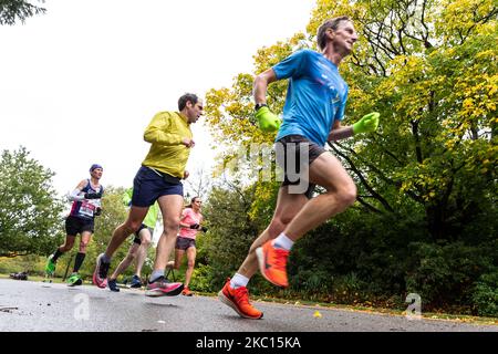 Tan Gower, un participant au marathon virtuel de Londres de Virgin Money et ses partisans sont vus courir par temps froid et pluvieux pour cancer Reaserch UK dans le parc de Dulwich dans le sud de Londres, Angleterre sur 4 octobre 2020. En raison de la pandémie de Covid-19, le Marathon de Londres pour le public était virtuel. Les participants se trouvent dans les lieux de leur choix, disposant d'une application mobile comme système de surveillance. La famille et les amis ont souvent pris des distances plus courtes pour soutenir le coureur. (Photo par Dominika Zarzycka/NurPhoto) Banque D'Images