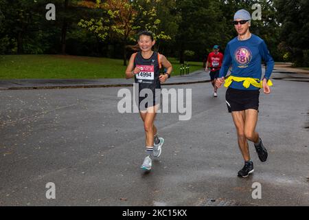 Amanda Nio, une participante au marathon virtuel de Londres de Virgin Money et ses supporters sont vus courir au parc Dulwich dans le sud de Londres, en Angleterre sur 4 octobre 2020. En raison de la pandémie de Covid-19, le Marathon de Londres pour le public était virtuel. Les participants se trouvent dans les lieux de leur choix, disposant d'une application mobile comme système de surveillance. La famille et les amis ont souvent pris des distances plus courtes pour soutenir le coureur. (Photo par Dominika Zarzycka/NurPhoto) Banque D'Images