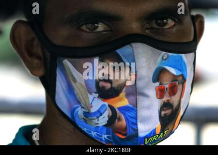 Un conducteur de tuk-tuk sri lankais portant un masque facial, imprimé avec les photos du capitaine indien de cricket Vira Kohli, regarde Colombo, Sri Lanka, sur 05 octobre 2020. Les autorités sri-lankaises ont fermé des écoles dans tout le pays et imposé un couvre-feu dimanche(04) dans trois banlieues de la province occidentale, après qu'une personne a été testée positive pour le coronavirus, après quoi 81 nouveaux Covid19 cas positifs ont été signalés jusqu'à présent sur (05) au Sri Lanka. (Photo de Thharaka Basnayaka/NurPhoto) Banque D'Images