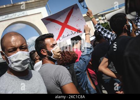 Une jeune protestante tunisienne jeune femme pose un écriteau qui lit en arabe « le projet de loi ne sera pas adopté », alors qu’elle assiste à une manifestation organisée à l’extérieur du Parlement tunisien à Bardo, à Tunis, pour protester contre le nouveau projet de loi sur la protection des forces de sécurité. La Tunisie sur 8 octobre 2020. (Photo de Chedly Ben Ibrahim/NurPhoto) Banque D'Images