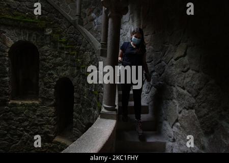 Les touristes portant des masques protecteurs traversent l'attraction "Pozo Iniciático" à Quinta das Regaleiras, à Sintra, Portugal. 09 octobre 2020. Avec la fin de la période des fêtes européennes, il est devenu évident que le Covid-19 a eu un impact significatif sur le secteur du tourisme après des décennies de croissance régulière. Les mesures visant à contenir la propagation du coronavirus, y compris les restrictions de mobilité et les interdictions de voyager, ont réduit les flux touristiques, selon la déclaration de l'agence de notation DBRS Morningstar. (Photo par Jorge Mantilla/NurPhoto) Banque D'Images