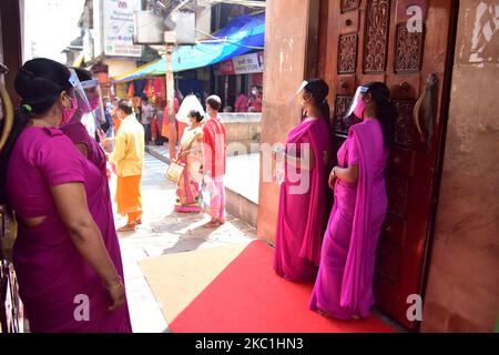 Les gardes de sécurité portent un masque facial et un bouclier en attendant que les dévotés se désinfectent les mains à l'intérieur des locaux du temple de Kamakhya, car il rouvre pour le public après un intervalle de près de six mois en raison du blocage du coronavirus avec certaines restrictions, à Guwahati, en Inde, sur 11 octobre 2020. (Photo par Anuwar Hazarika/NurPhoto) Banque D'Images