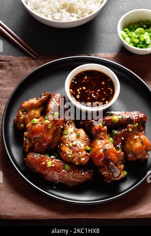 Ailes de poulet au miel et au soja avec sauce sur l'assiette. Vue rapprochée Banque D'Images