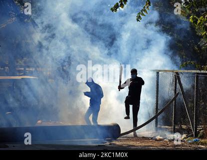 Un manifestant réagit après que la police indienne ait tiré des bidons de fumée lacrymogène près du site de la bataille des armes à feu dans la région de Barzulla, à Srinagar, au Cachemire, sur le 12 octobre 2020.des affrontements ont éclaté entre manifestants en colère et la police peu après la fin de la rencontre, au cours desquels deux militants, dont le commandant supérieur, ont été tués. (Photo par Faisal Khan/NurPhoto) Banque D'Images