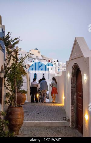 Heure magique au crépuscule juste après le coucher du soleil dans le célèbre village d'Oia avec des églises à dôme bleu, des moulins à vent et blanchi à la chaux avec des bâtiments d'architecture traditionnelle se tenant sur le bord de la falaise dans l'île volcanique de Santorini en Grèce. L'île méditerranéenne de la mer Égée est un volcan habité, l'une des destinations de voyage les plus célèbres au monde en particulier pour les couples et la lune de miel car il y a un coucher de soleil incroyable chaque jour avec une vue incroyable sur la caldeira. En 2020 Santorini plus grec îles essayé d'attirer des touristes en dépit de la faible circulation des passagers, quarantaine an Banque D'Images