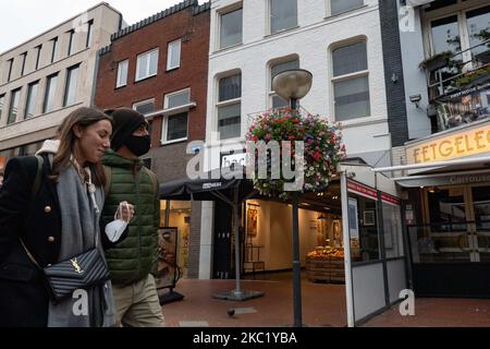 Les gens d'Eindhoven passent devant des cafés et des bars fermés pendant le confinement partiel et la vie quotidienne dans la ville d'Eindhoven aux pays-Bas avec des gens portant un masque facial lorsqu'ils sont à l'extérieur ou à vélo comme mesure de protection contre la propagation de l'épidémie de coronavirus Covid-19. Le mardi 13 octobre 2020, le Premier ministre néerlandais Mark Rutte a annoncé que les pays-Bas doivent revenir à un verrouillage partiel, la fermeture des bars, cafés et restaurants, l'utilisation obligatoire du masque facial à l'intérieur, la limitation au nombre de personnes se rassemblent à l'intérieur, les activités sportives et plus sont également un Banque D'Images