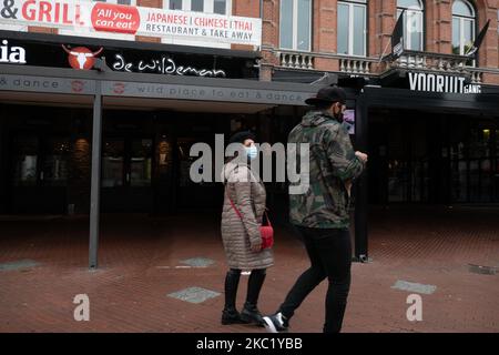 Les gens d'Eindhoven passent devant des cafés et des bars fermés pendant le confinement partiel et la vie quotidienne dans la ville d'Eindhoven aux pays-Bas avec des gens portant un masque facial lorsqu'ils sont à l'extérieur ou à vélo comme mesure de protection contre la propagation de l'épidémie de coronavirus Covid-19. Le mardi 13 octobre 2020, le Premier ministre néerlandais Mark Rutte a annoncé que les pays-Bas doivent revenir à un verrouillage partiel, la fermeture des bars, cafés et restaurants, l'utilisation obligatoire du masque facial à l'intérieur, la limitation au nombre de personnes se rassemblent à l'intérieur, les activités sportives et plus sont également un Banque D'Images