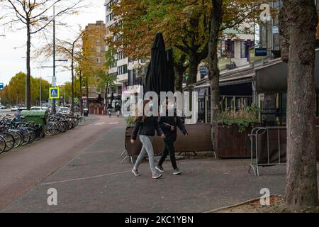 Les gens d'Eindhoven passent devant des cafés et des bars fermés pendant le confinement partiel et la vie quotidienne dans la ville d'Eindhoven aux pays-Bas avec des gens portant un masque facial lorsqu'ils sont à l'extérieur ou à vélo comme mesure de protection contre la propagation de l'épidémie de coronavirus Covid-19. Le mardi 13 octobre 2020, le Premier ministre néerlandais Mark Rutte a annoncé que les pays-Bas doivent revenir à un verrouillage partiel, la fermeture des bars, cafés et restaurants, l'utilisation obligatoire du masque facial à l'intérieur, la limitation au nombre de personnes se rassemblent à l'intérieur, les activités sportives et plus sont également un Banque D'Images