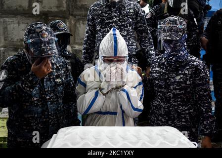 Le détenu politique Reina Mae Nasino, portant un équipement de protection individuelle (EPI) complet, assiste à l'enterrement de son bébé de trois mois dans un cimetière à Manille, aux Philippines, sur 16 octobre 2020. La Cour de première instance régionale de Manille a accordé à Nasino un congé de 6 heures pour assister aux funérailles et à l'enterrement de sa fille, River.(photo de Lisa Marie David/NurPhoto) Banque D'Images