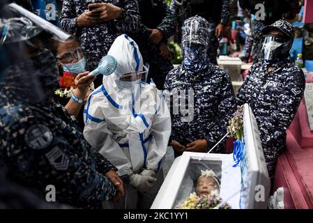 Le détenu politique Reina Mae Nasino, portant un équipement de protection individuelle (EPI) complet, assiste à l'enterrement de son bébé de trois mois dans un cimetière à Manille, aux Philippines, sur 16 octobre 2020. La Cour de première instance régionale de Manille a accordé à Nasino un congé de 6 heures pour assister aux funérailles et à l'enterrement de sa fille, River.(photo de Lisa Marie David/NurPhoto) Banque D'Images