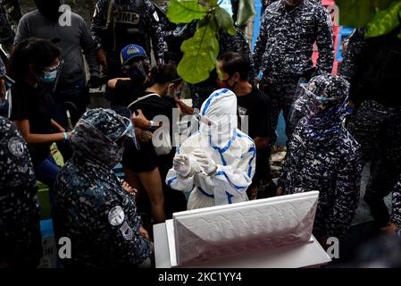 Le détenu politique Reina Mae Nasino, portant un équipement de protection individuelle (EPI) complet, assiste à l'enterrement de son bébé de trois mois dans un cimetière à Manille, aux Philippines, sur 16 octobre 2020. La Cour de première instance régionale de Manille a accordé à Nasino un congé de 6 heures pour assister aux funérailles et à l'enterrement de sa fille, River.(photo de Lisa Marie David/NurPhoto) Banque D'Images