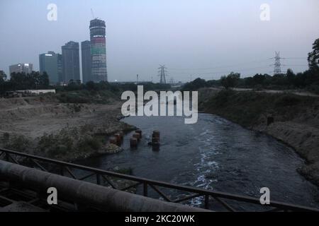 Vue sur un chantier en cours de construction par un jour trouble, la qualité de l'air se détériore et de la mousse toxique flotte sur la surface de la rivière Yamuna, dans la région de Kalindi Kunj, à 16 octobre 2020, à New Delhi, en Inde. La capitale nationale est témoin d'un pic de la pollution atmosphérique presque chaque année en hiver en raison de diverses conditions, notamment l'activité de construction et la combustion des chaumes dans les États voisins. (Photo de Mayank Makhija/NurPhoto) Banque D'Images