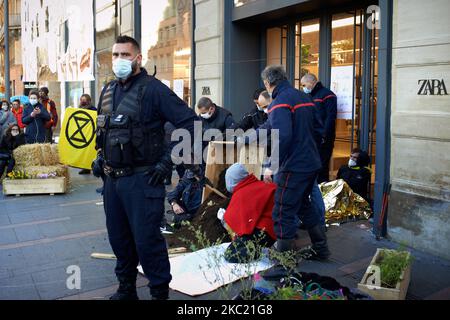 Les policiers extraient des militants enchaînés aux portes d'entrée du magasin Zara. Des membres et des activistes de l'ONG XR (rébellion d'extinction) et des jeunes pour le climat ont organisé une journée nationale de protestation contre la mode rapide. Ils ont bloqué les portes d'entrée d'un magasin Zara se faisant enchaîner devant le magasin et ont été délogés par la police après deux heures. Ils veulent sensibiliser à l'empreinte carbone et à l'empreinte écologique de la mode rapide. Des actions similaires ont eu lieu ailleurs en France. Sur 17 octobre 2020 à Toulouse (photo d'Alain Pitton/NurPhoto) Banque D'Images