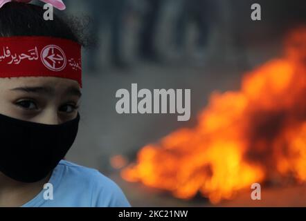 Une fille portant un masque facial protecteur et le bandeau du Front populaire pour la libération de la Palestine (PFLP) regarde pendant une manifestation anti-israélienne à Gaza 17 octobre 2020. (Photo de Majdi Fathi/NurPhoto) Banque D'Images
