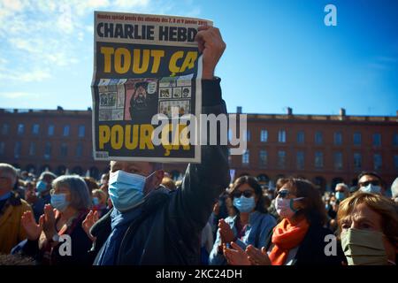 Un homme montre une couverture du journal Charlie Hebdo lisant "tout cela pour ça". Après l'assassinat de Samuel Paty, professeur de géographie-histoire, à Conflans-Sainte-Honorine (Yvelines) sur 16 octobre, plusieurs milliers de personnes se sont rassemblées sur la place principale de Toulouse, en face de la mairie, le Capitole, pour défendre la liberté d'expression et rendre hommage à Samuel. Certains sont venus avec une couverture de Charlie Hebdo comme l'enseignant a été tué après avoir montré à ses élèves les caricatures de Charlie Hebdo de Muhammed. Le tueur a été tué par la police française après. Sur 18 octobre 2020 à Tou Banque D'Images