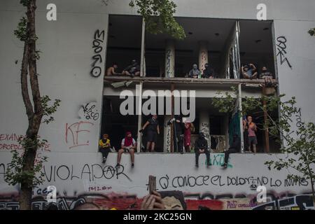 Un groupe de personnes observent la manifestation d'un bâtiment abandonné près de Plaza Dignidad (ancienne Plaza Italia) au milieu de la commémoration, de la manifestation et de la manifestation du premier anniversaire depuis le début de l'épidémie sociale au Chili. Sur 18 octobre 2020 à Santiago du Chili, Chili. (Photo de Claudio Abarca Sandoval/NurPhoto) Banque D'Images