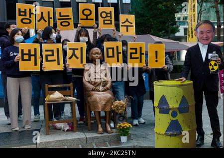 Centre de surveillance de la radioactivité civile, activistes du syndicat des mouvements environnementaux avec un manifestant qui porte un masque de dépeindre le Premier ministre japonais Yoshihide Suga simule l'évacuation de l'eau radioactive dans l'océan, ils tiennent également une plaque qui dit, ne jetez pas d'eau contaminée radioactive, Lors d'un rassemblement pour s'opposer à la libération d'eau contenant des matières radioactives stockées à la centrale nucléaire de Fukushima au Japon sur 19 octobre 2020 à Séoul, en Corée du Sud. La centrale de Fukushima a été paralysée depuis l’énorme tsunami de mars 2011. (Photo de Chris Jung/NurPhoto) Banque D'Images