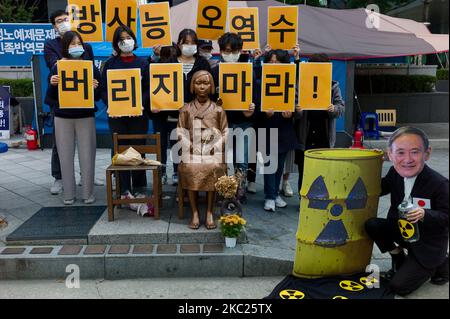 Centre de surveillance de la radioactivité civile, activistes du syndicat des mouvements environnementaux avec un manifestant qui porte un masque de dépeindre le Premier ministre japonais Yoshihide Suga simule l'évacuation de l'eau radioactive dans l'océan, ils tiennent également une plaque qui dit, ne jetez pas d'eau contaminée radioactive, Lors d'un rassemblement pour s'opposer à la libération d'eau contenant des matières radioactives stockées à la centrale nucléaire de Fukushima au Japon sur 19 octobre 2020 à Séoul, en Corée du Sud. La centrale de Fukushima a été paralysée depuis l’énorme tsunami de mars 2011. (Photo de Chris Jung/NurPhoto) Banque D'Images