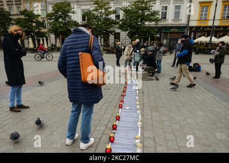 Les membres de la KOD (Commission de défense de la démocratie) commémorent le troisième anniversaire de la mort de Piotr Szcz?sny lors de la veillée aux chandelles sur la place du marché principal de Cracovie. Piotr Szczesny, chimiste polonais, s'est mis en feu sur 19 octobre 2017, pour protester contre la politique du parti droit et Justice au pouvoir et contre la discrimination politique (racisme, homophobie et autres formes) dans la vie sociale polonaise. Il mourut 10 jours plus tard à l'hôpital sur 29 octobre 2017 sans retrouver la conscience. Lundi, 19 octobre 2020, à Cracovie, petite Pologne Voivodeship, Pologne. (Photo par Art Banque D'Images