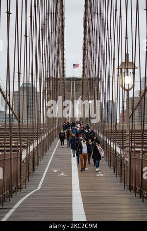 Des centaines de personnes sur le pont de Brooklyn dans la ville de New York aux États-Unis comme vu pendant une journée nuageux avec des touristes et des locaux sur elle. Le célèbre pont, un point de repère pour NYC et les États-Unis d'Amérique est un pont suspendu à câble hybride qui enjambe l'East River entre les quartiers de Manhattan et Brooklyn. Le pont historique de New York a été construit entre 1869 et 1883. New York, Etats-Unis sur 13 février 2020 (photo de Nicolas Economou/NurPhoto) Banque D'Images