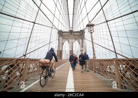 Piétons et vélos sur le pont de brooklyn. Le pont de Brooklyn dans la ville de New York aux États-Unis comme vu pendant une journée nuageuse avec les touristes et les locaux sur elle. Le célèbre pont, un point de repère pour NYC et les États-Unis d'Amérique est un pont suspendu à câble hybride qui enjambe l'East River entre les quartiers de Manhattan et Brooklyn. Le pont historique de New York a été construit entre 1869 et 1883. New York, Etats-Unis sur 13 février 2020 (photo de Nicolas Economou/NurPhoto) Banque D'Images