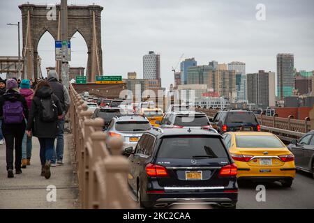 Les gens parmi eux beaucoup de touristes et de la circulation avec des voitures du pont de Brooklyn dans la ville de New York aux États-Unis comme vu pendant une journée nuageux avec des touristes et des locaux sur elle. Le célèbre pont, un point de repère pour NYC et les États-Unis d'Amérique est un pont suspendu à câble hybride qui enjambe l'East River entre les quartiers de Manhattan et Brooklyn. Le pont historique de New York a été construit entre 1869 et 1883. New York, Etats-Unis sur 13 février 2020 (photo de Nicolas Economou/NurPhoto) Banque D'Images